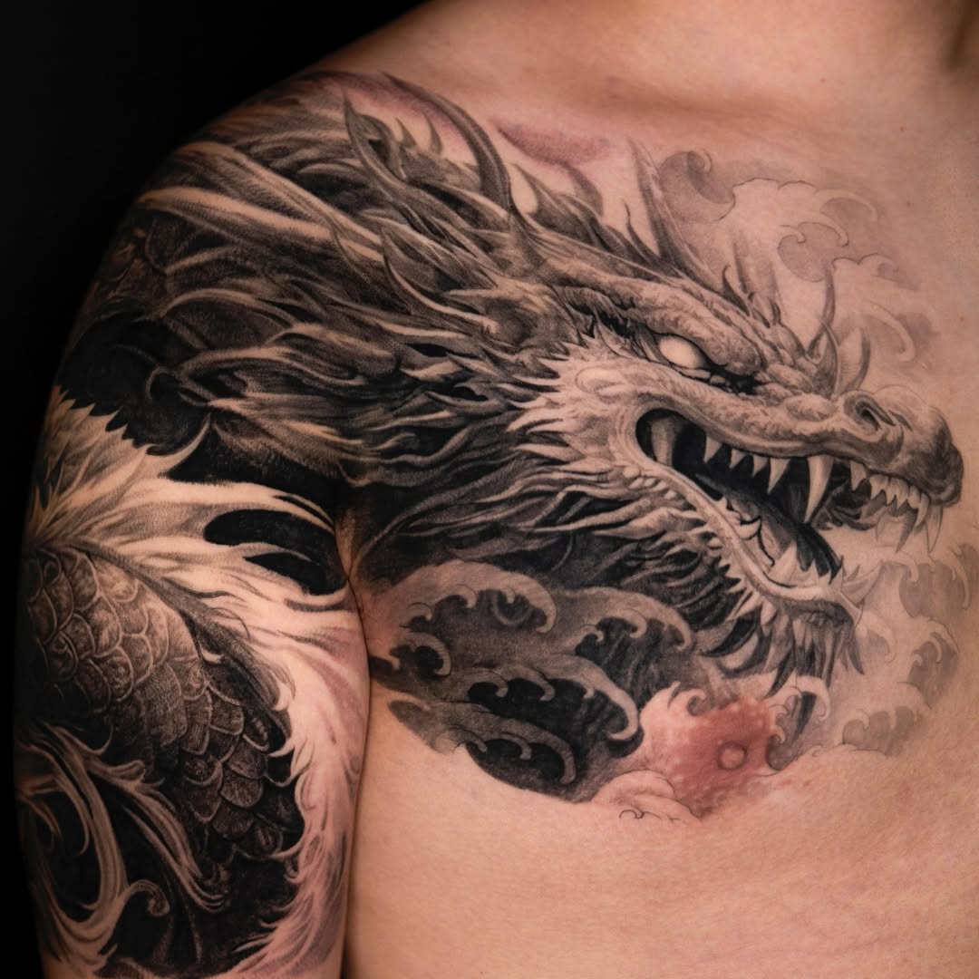 Stunning dragon shoulder tattoo in grayscale ink