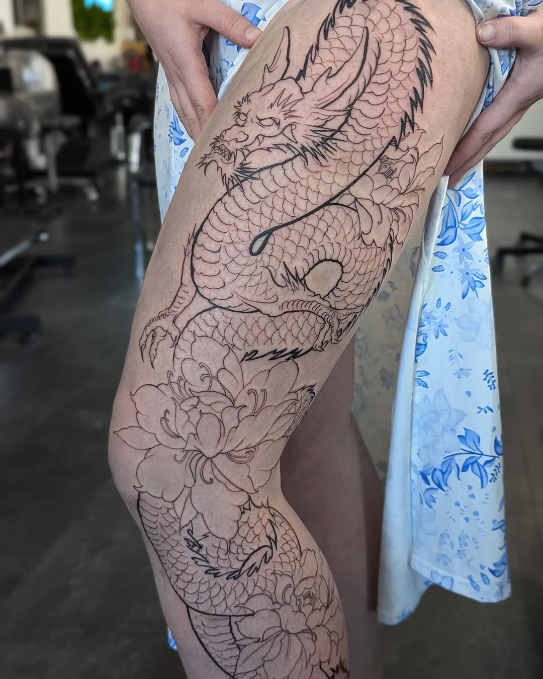 Intricate dragon tattoo entwined with floral elements