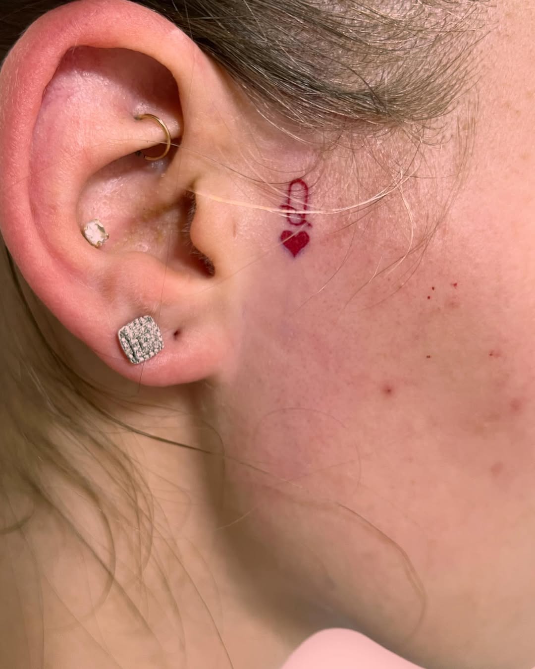 Charming minimalist heart tattoo behind the ear