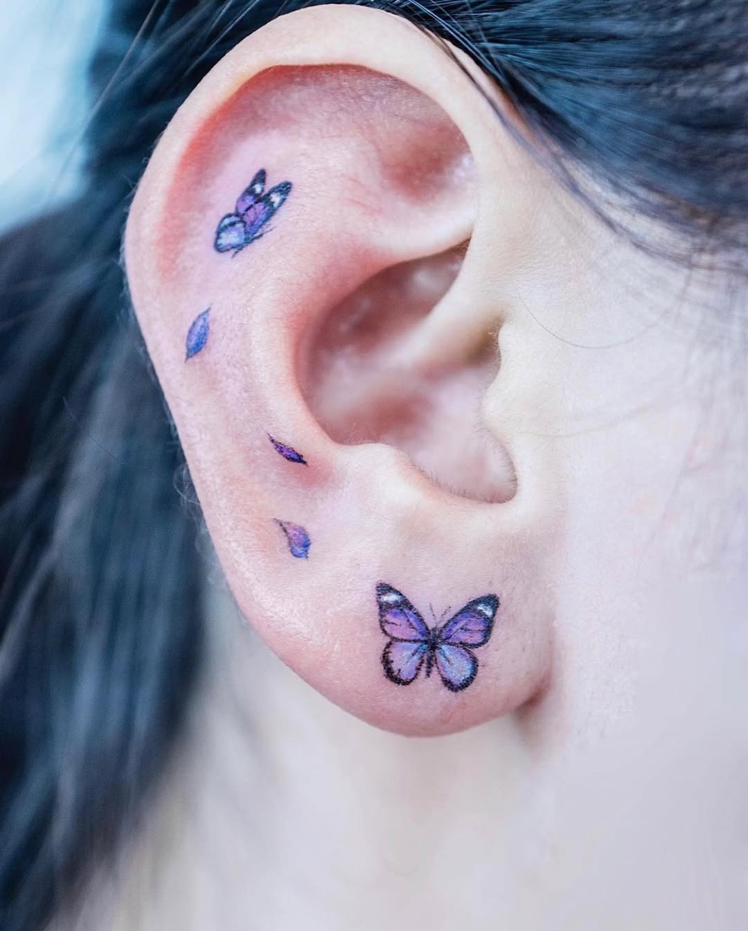 Vibrant butterfly tattoos adorning the ear
