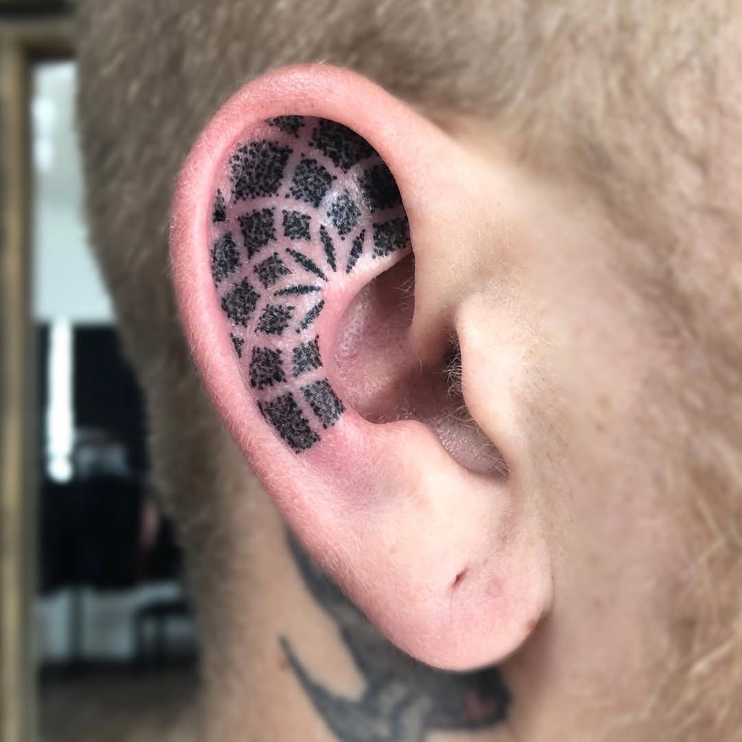 Unique geometric ear tattoo design in black ink