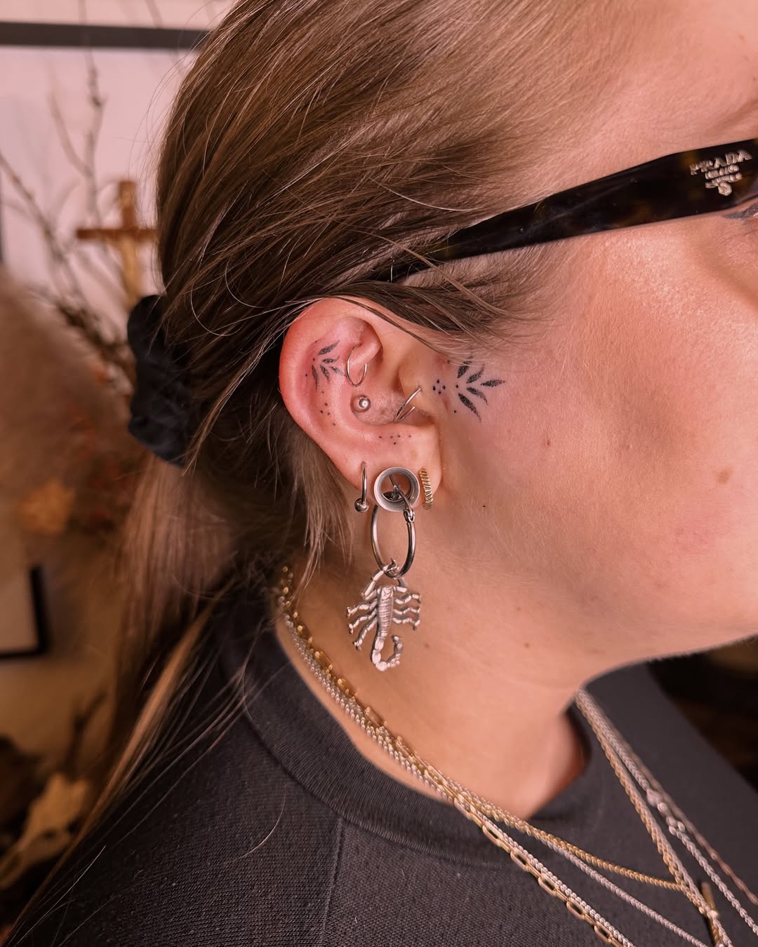 Stylish ear tattoos with scorpion and leaves