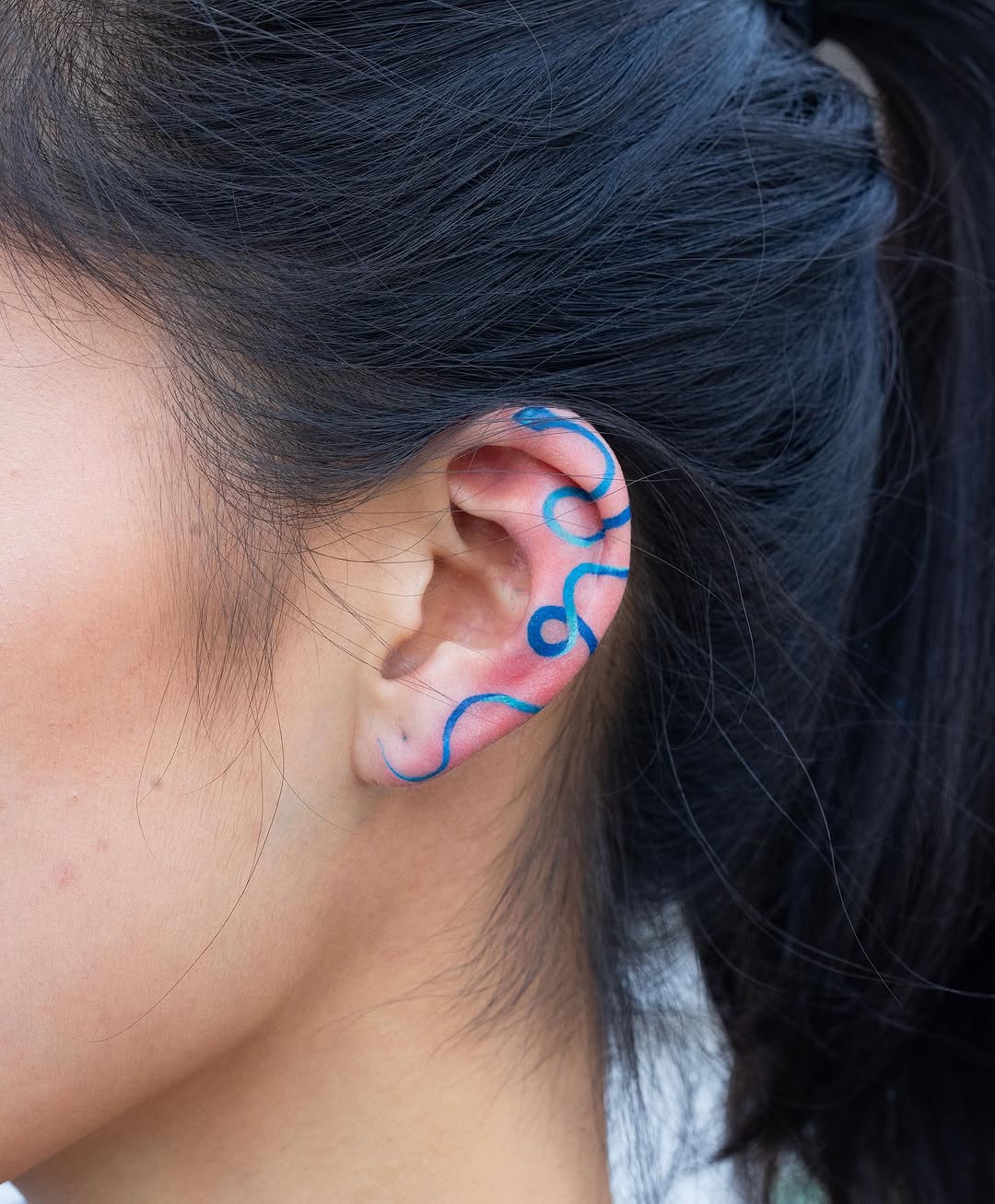 Stylish wavy line tattoo on the ear