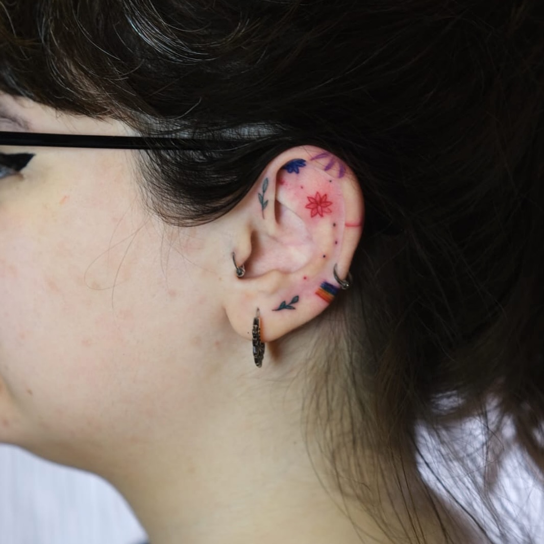 Colorful and intricate ear tattoo artistry