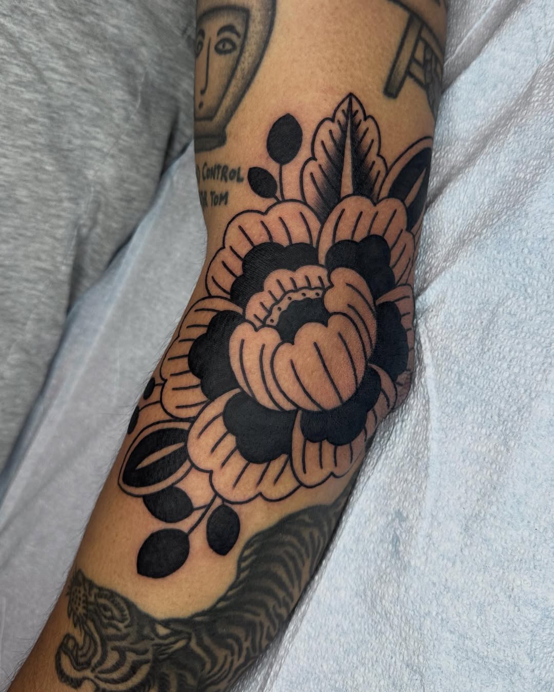 Bold floral elbow tattoo with intricate details