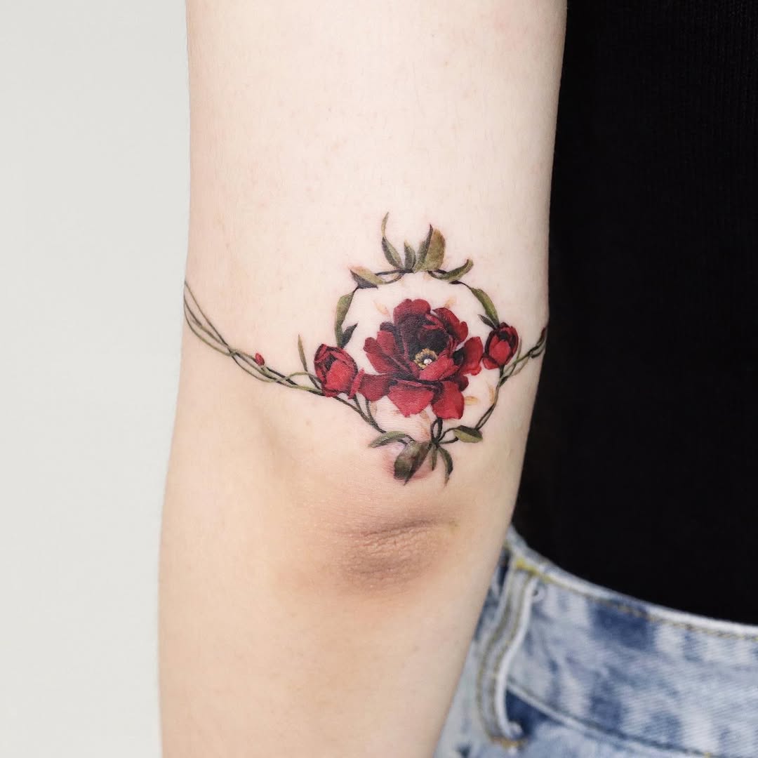 Vibrant red roses enhance elbow tattoo aesthetics