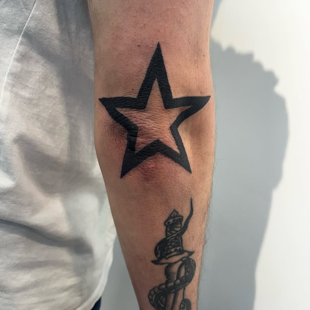 Bold star tattoo on the elbow