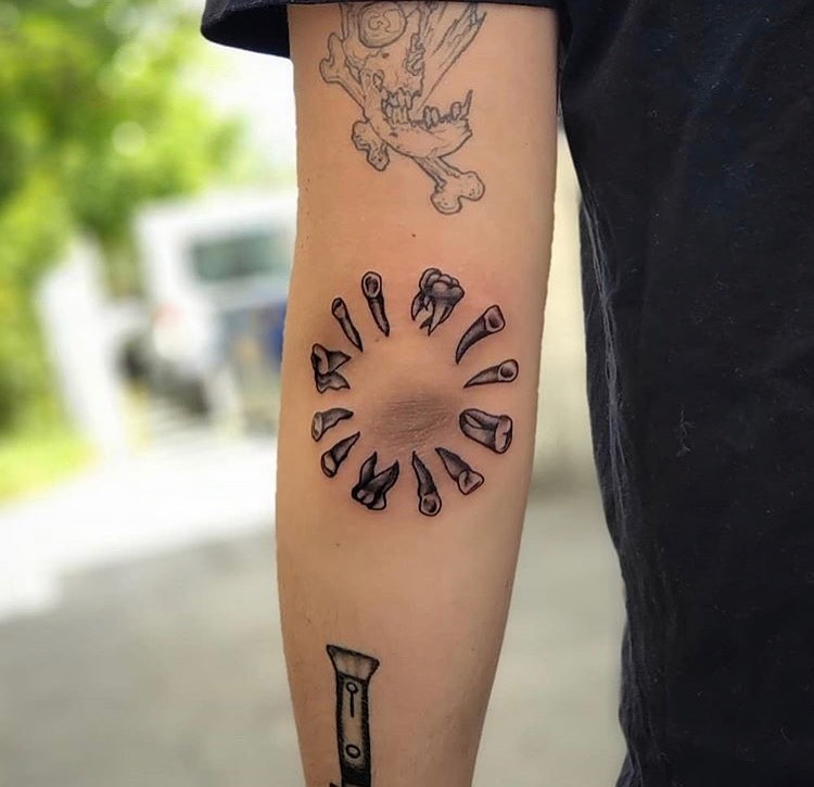 Unique artistic elbow tattoo featuring tool circle