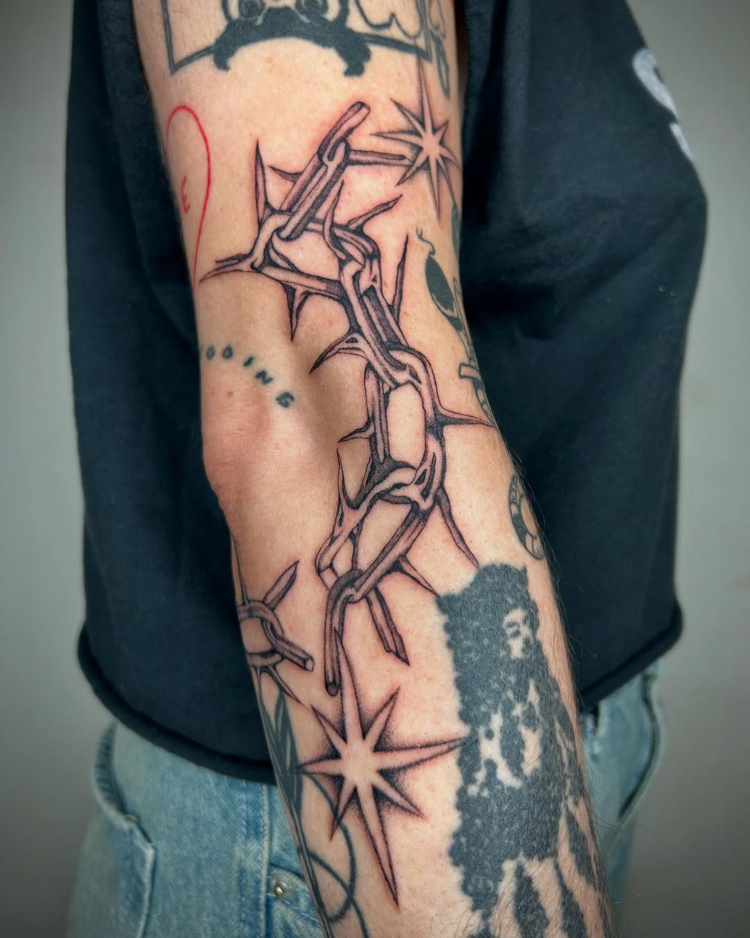 Unique chain and star elbow tattoo design