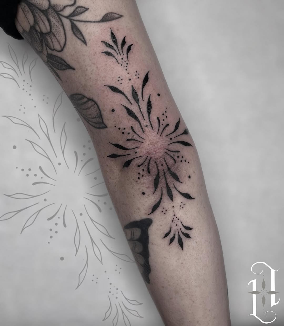 Elegant floral elbow tattoo with bold black ink