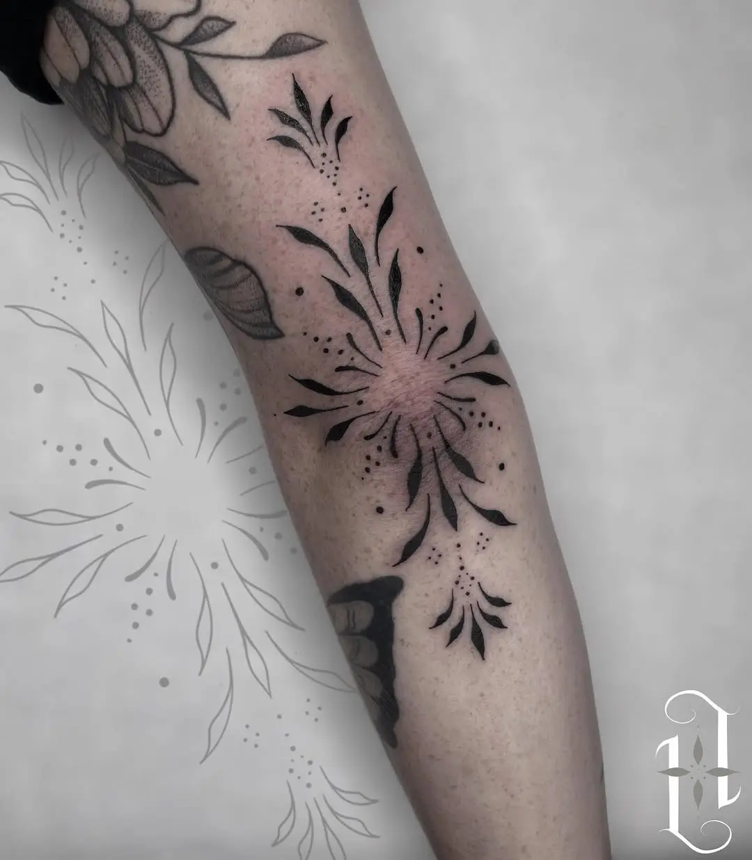 Elegant floral elbow tattoo with bold black ink