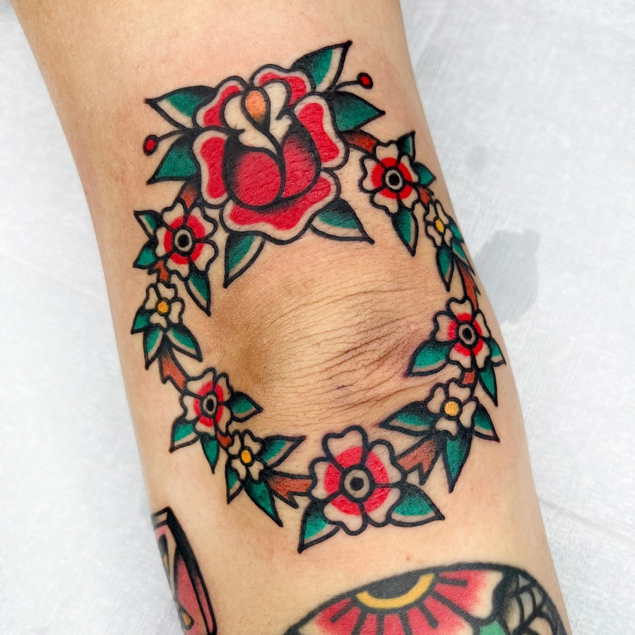 Vibrant floral elbow tattoo with bold colors