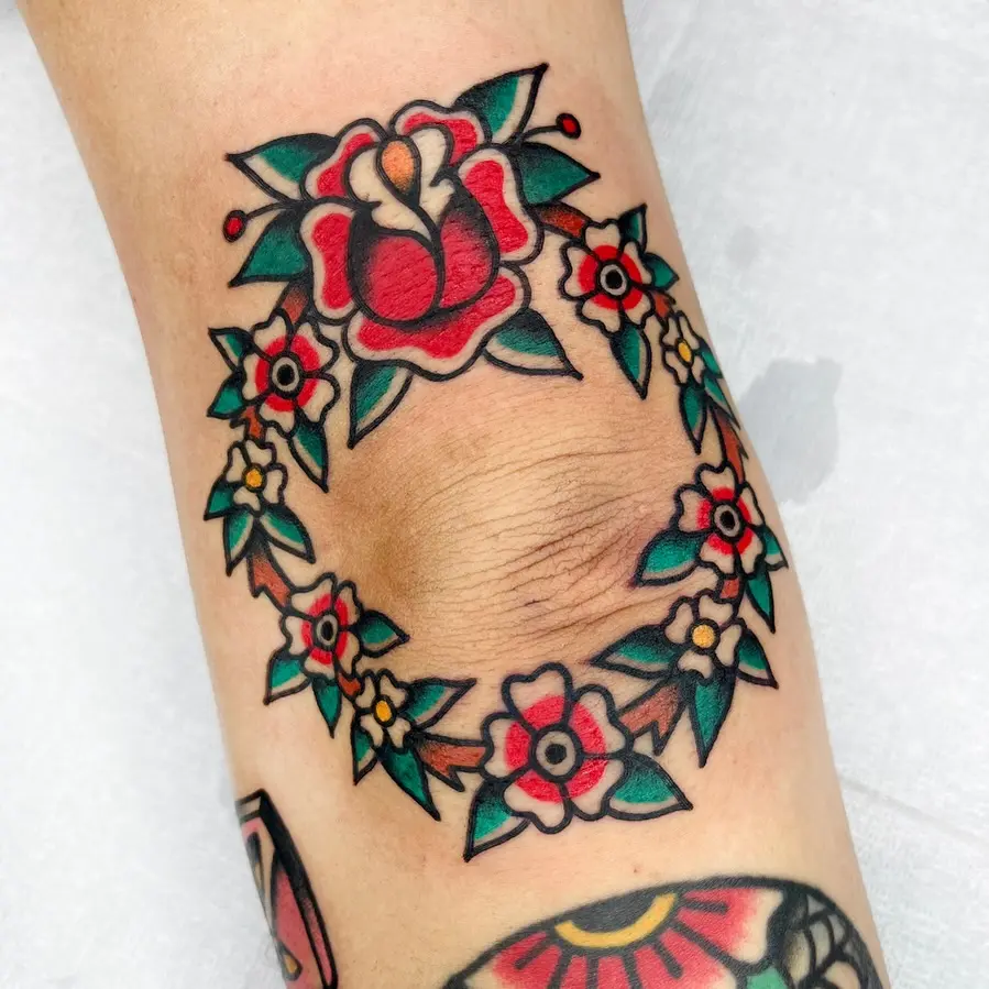 Vibrant floral elbow tattoo with bold colors