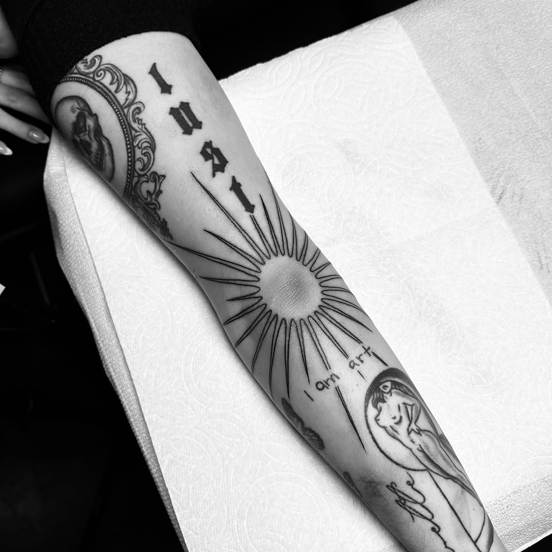 Striking elbow tattoo blending lust and sun motifs