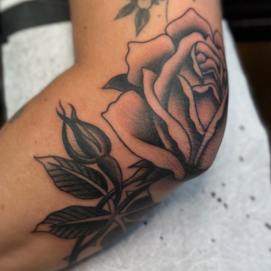 Elegant rose tattoo enhancing elbow aesthetics