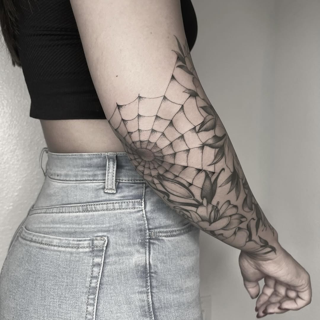 Stunning spider web and floral elbow tattoo