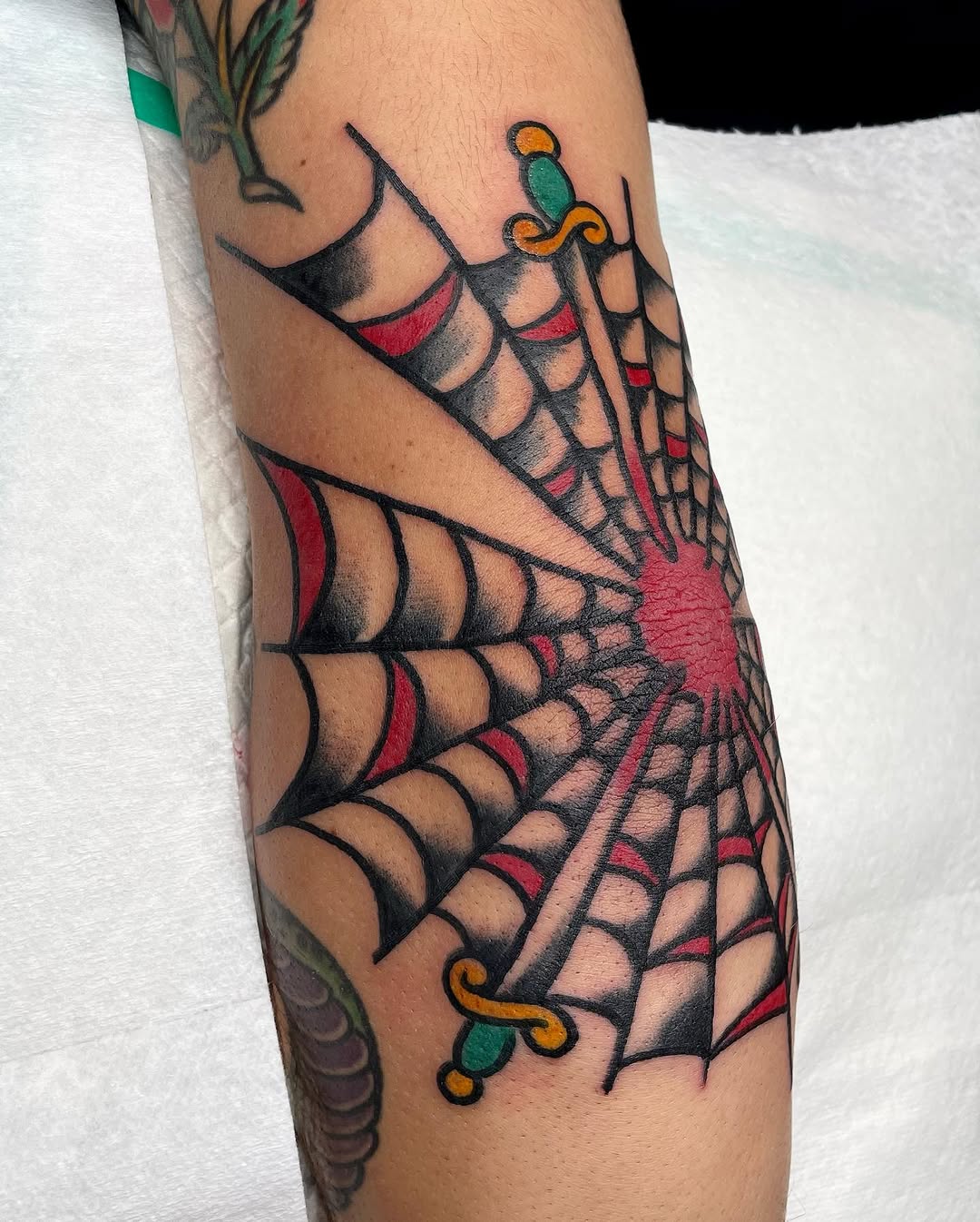 Intricate spider web tattoo on the elbow