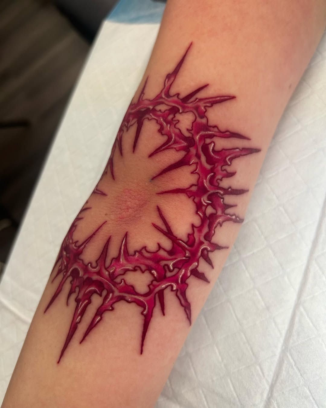 Intricate spiky elbow tattoo with bold colors