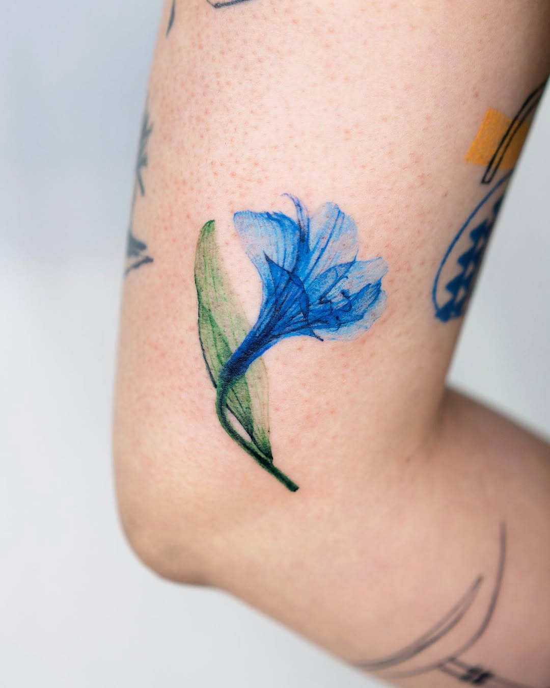 Stunning blue flower on elbow tattoo