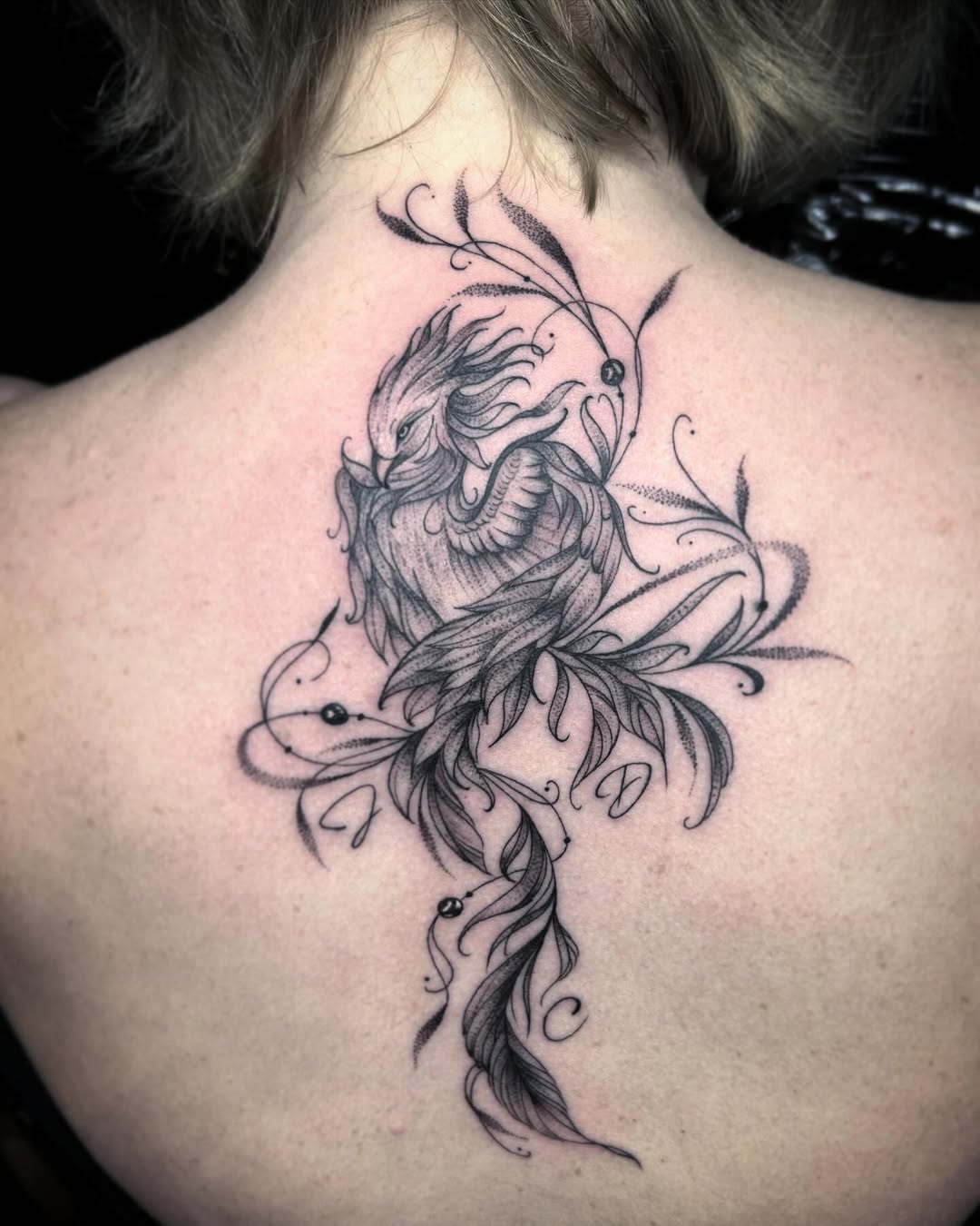 Elegant phoenix tattoo with floral elements