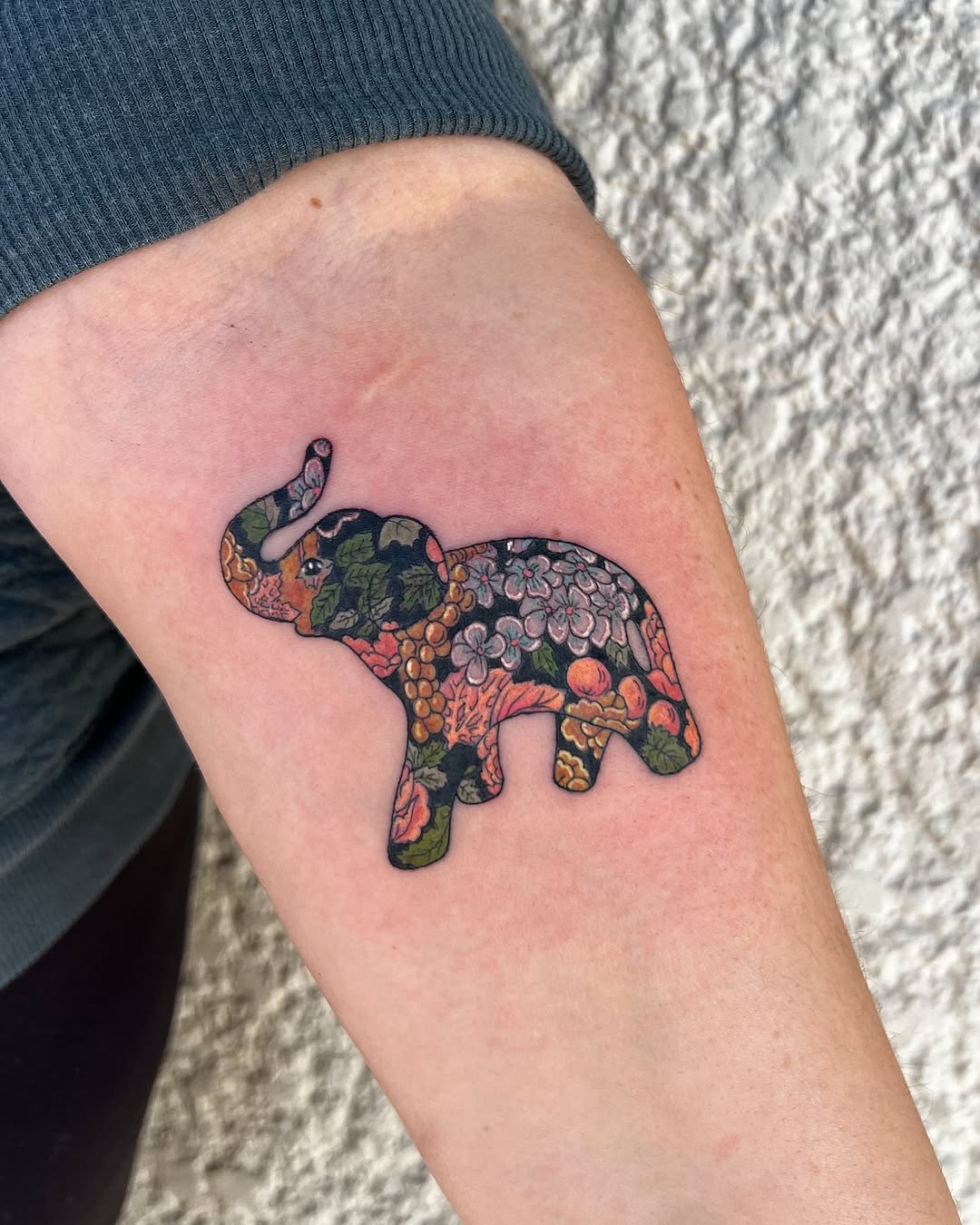 Vibrant elephant tattoo filled with floral patterns