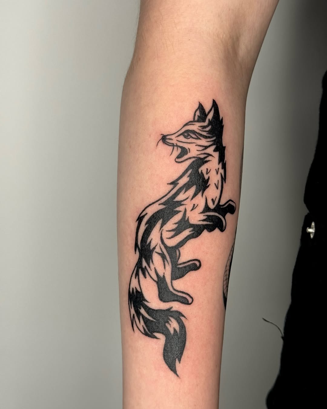 Dynamic fox tattoo showcasing bold black ink