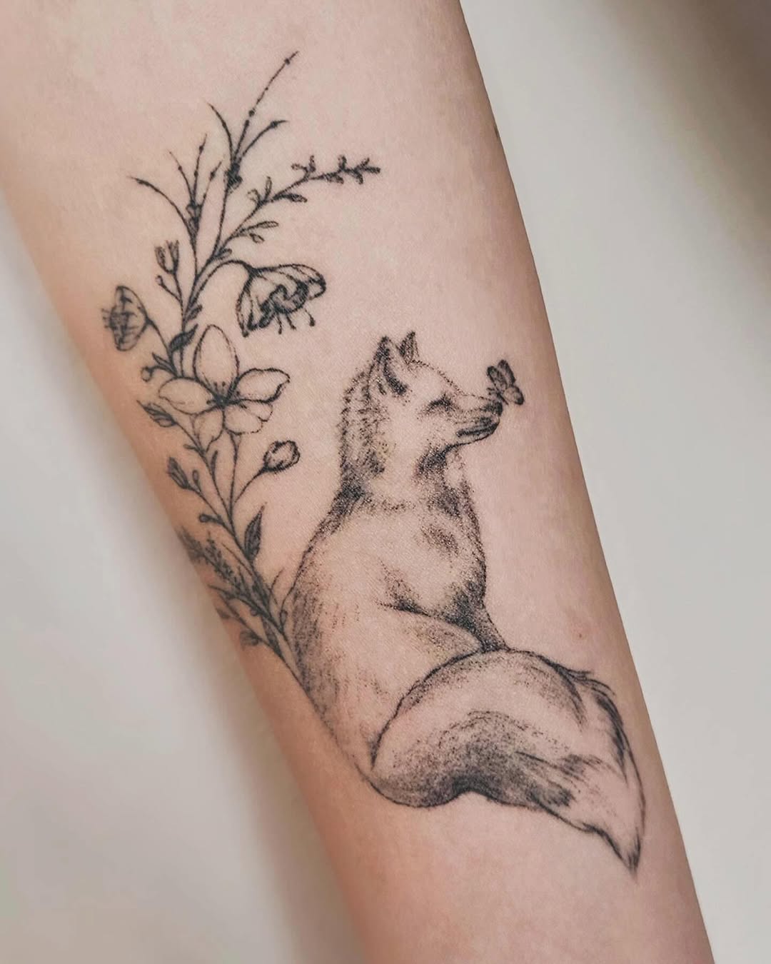 Elegant fox tattoo with floral accents