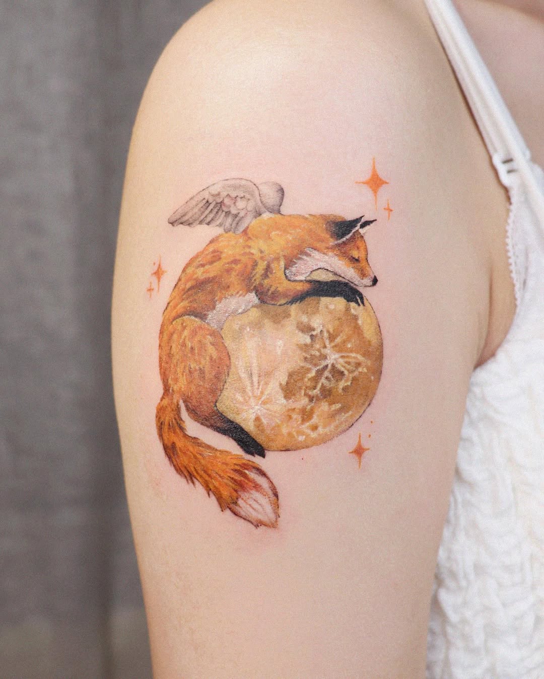 Whimsical fox tattoo resting on moon