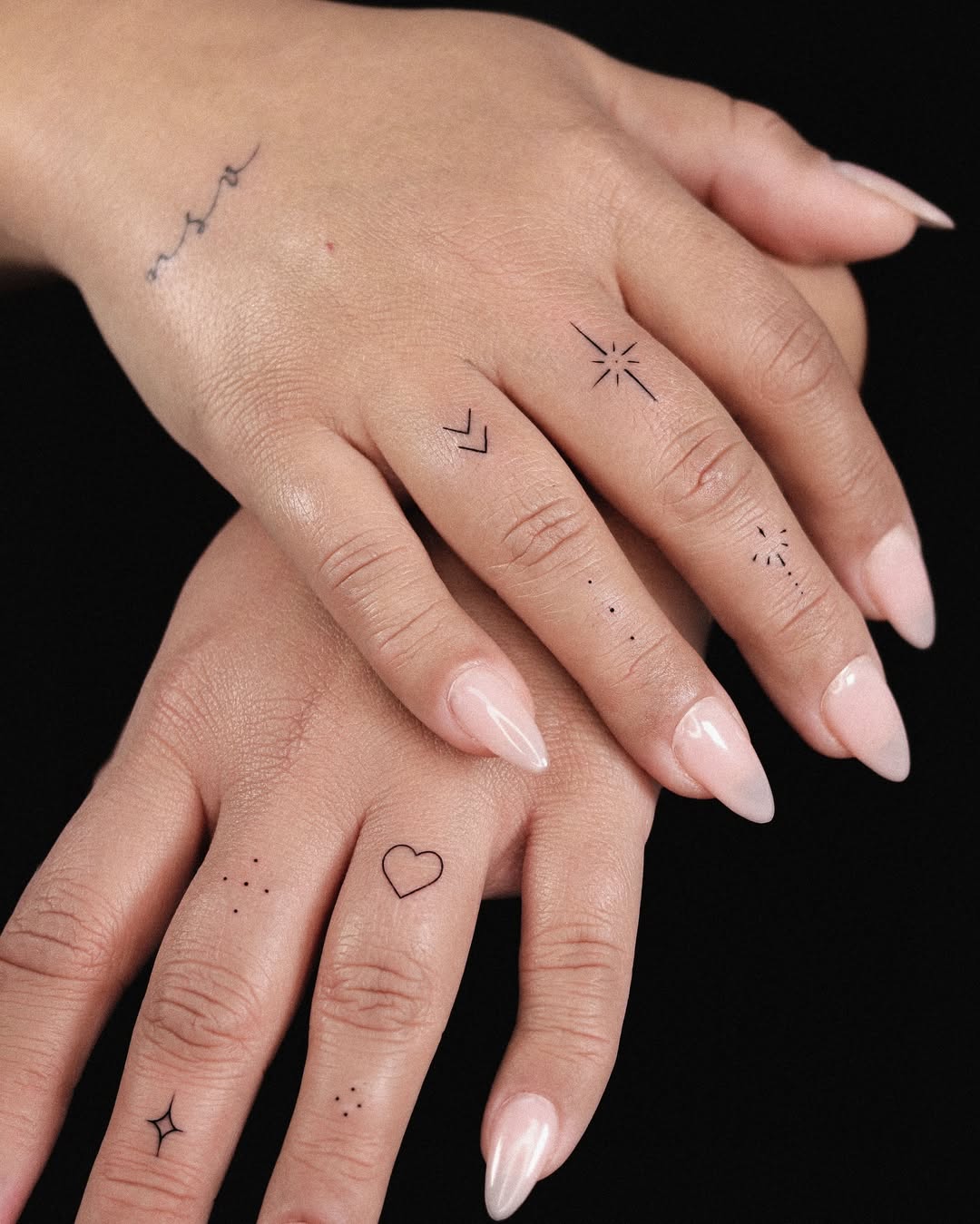 Delicate heart tattoos on hands and fingers