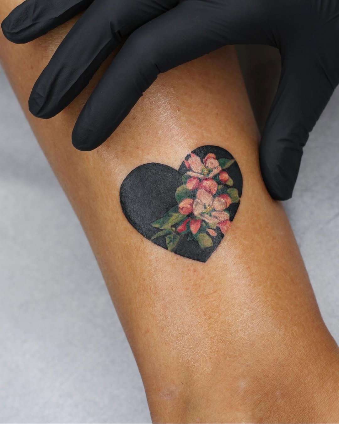 Elegant floral heart tattoo on the forearm