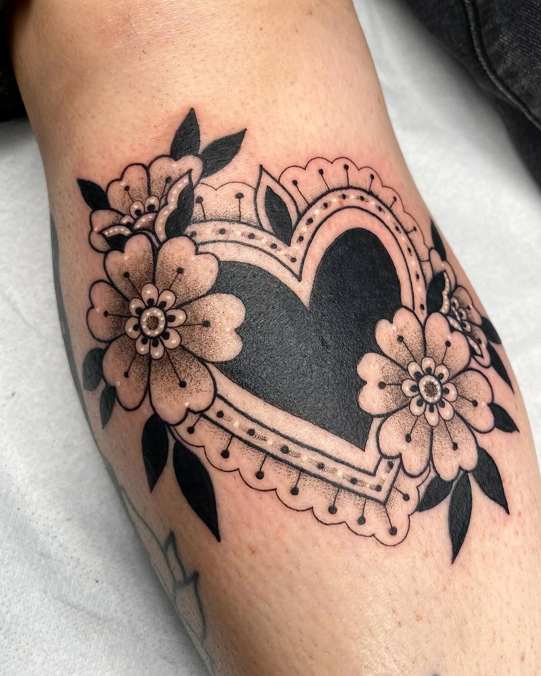 Charming heart tattoo with floral elements