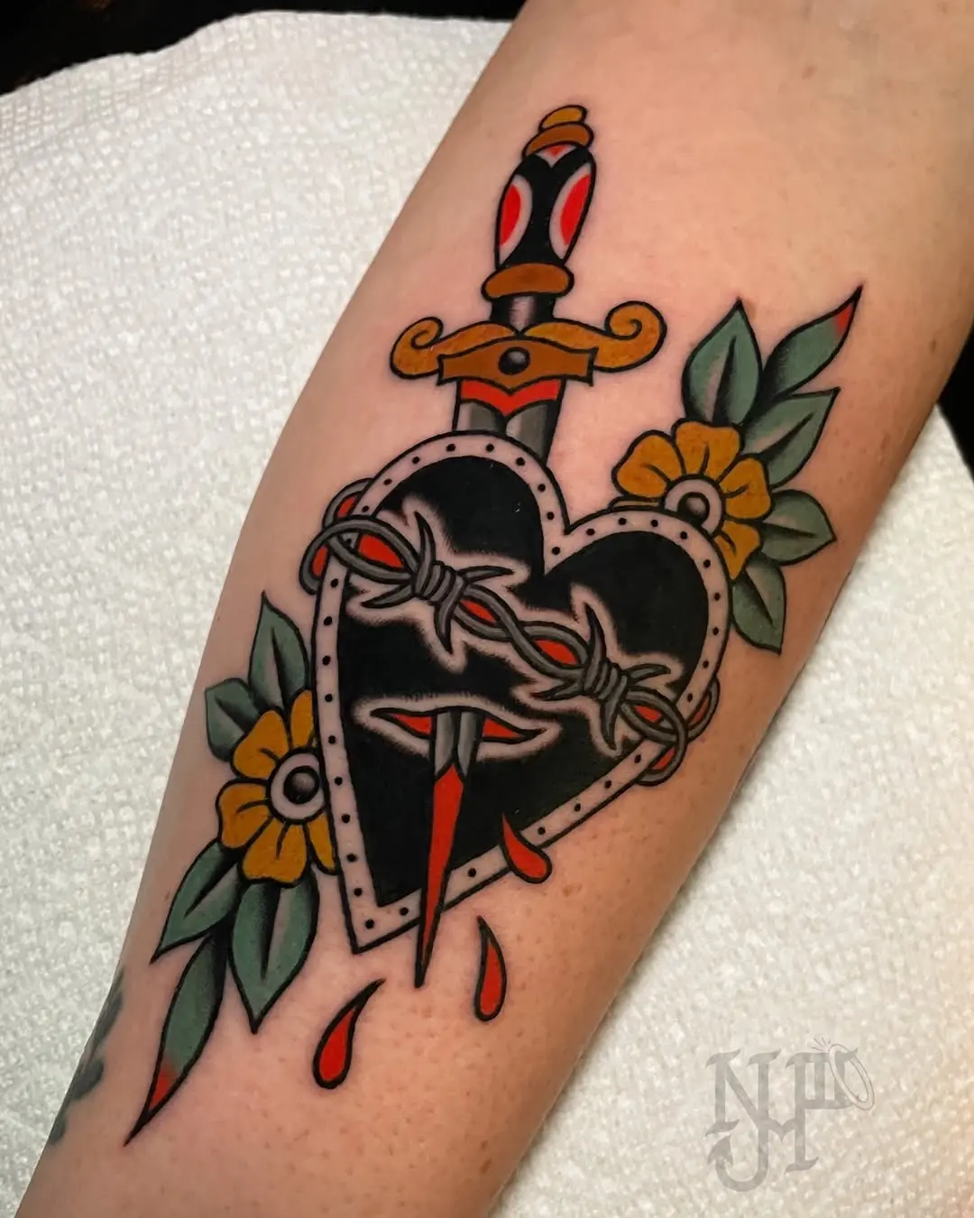 Bold heart tattoo with a striking dagger design