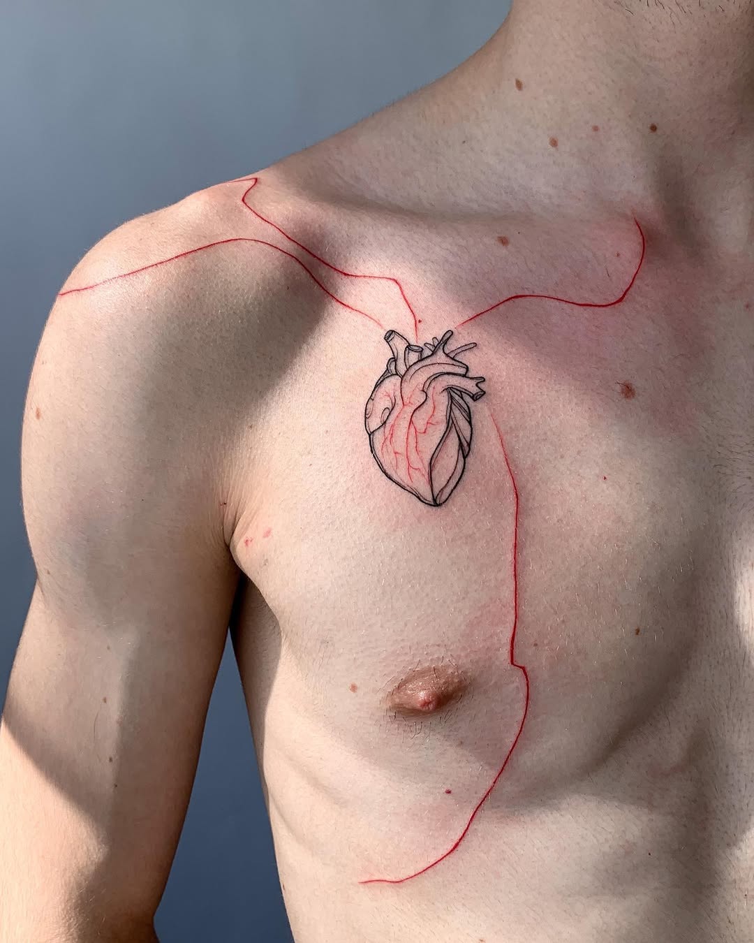 Intricate heart tattoo with bold red lines