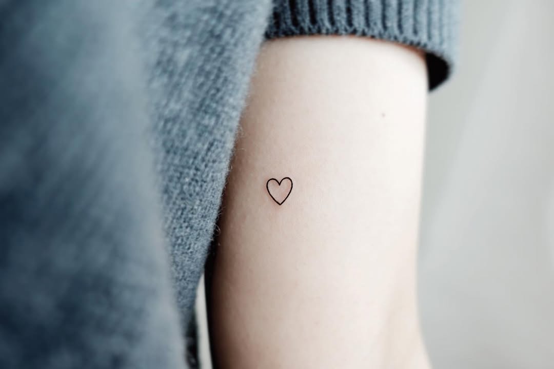 Minimalist heart tattoo on the forearm