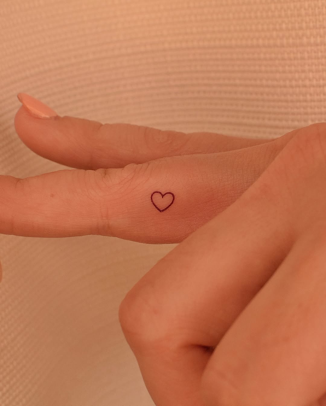 A tiny heart tattoo on the finger