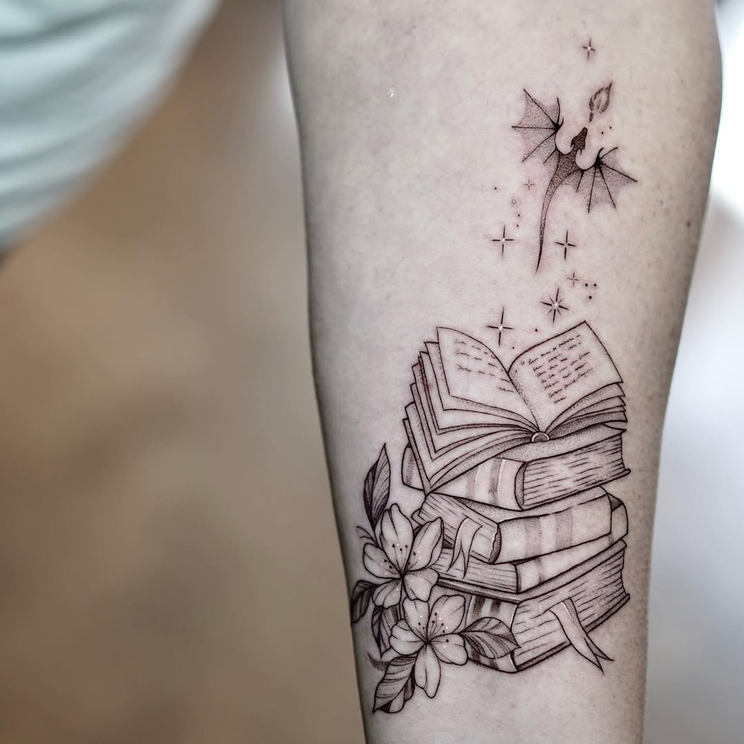 Elegant tattoo of stacked books and flower.