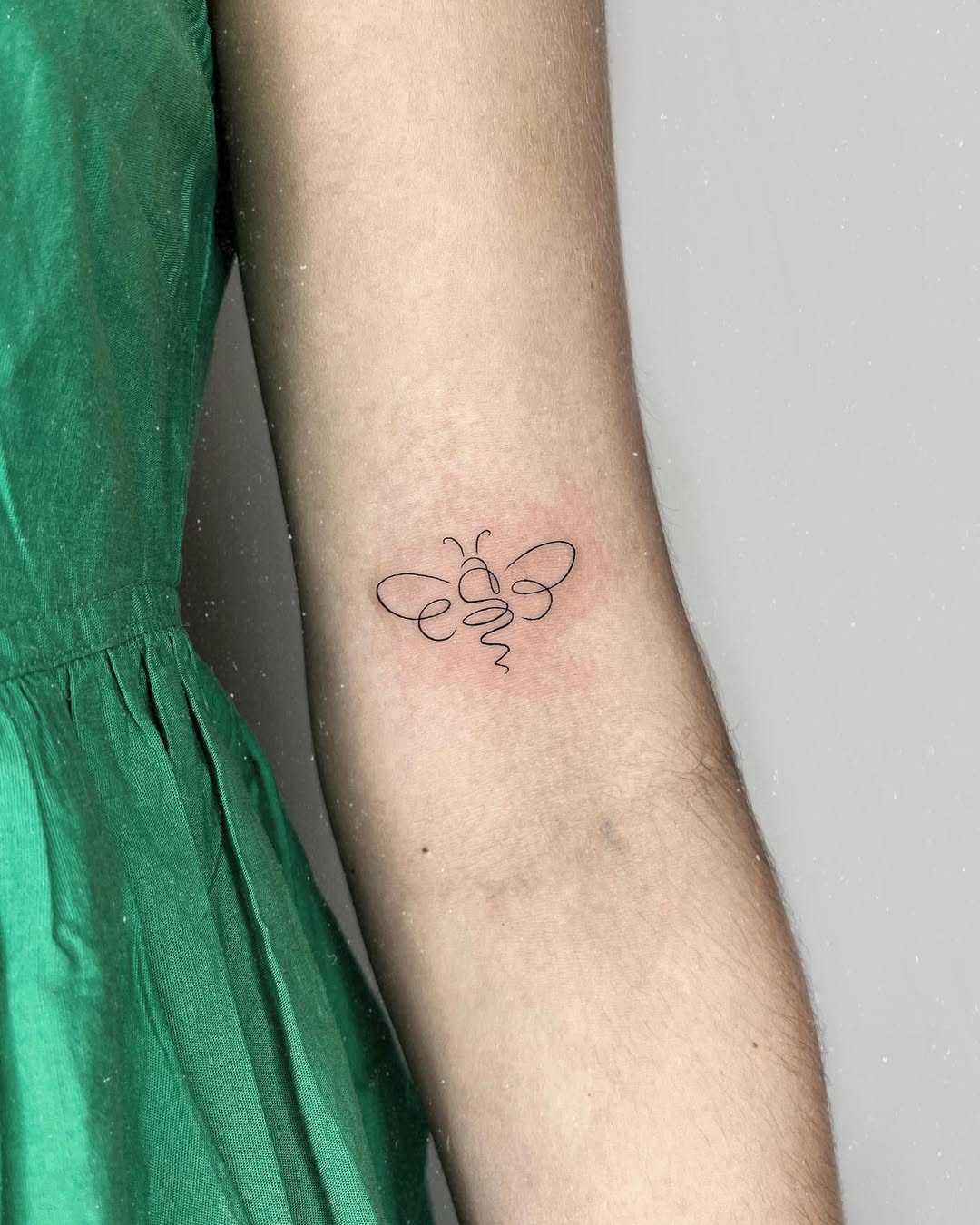 Minimalist bee tattoo with elegant line art