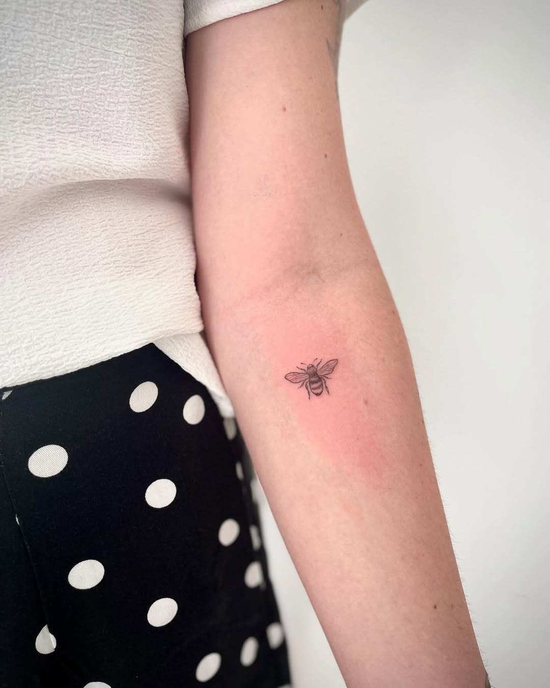 Charming minimalist bee tattoo on the arm