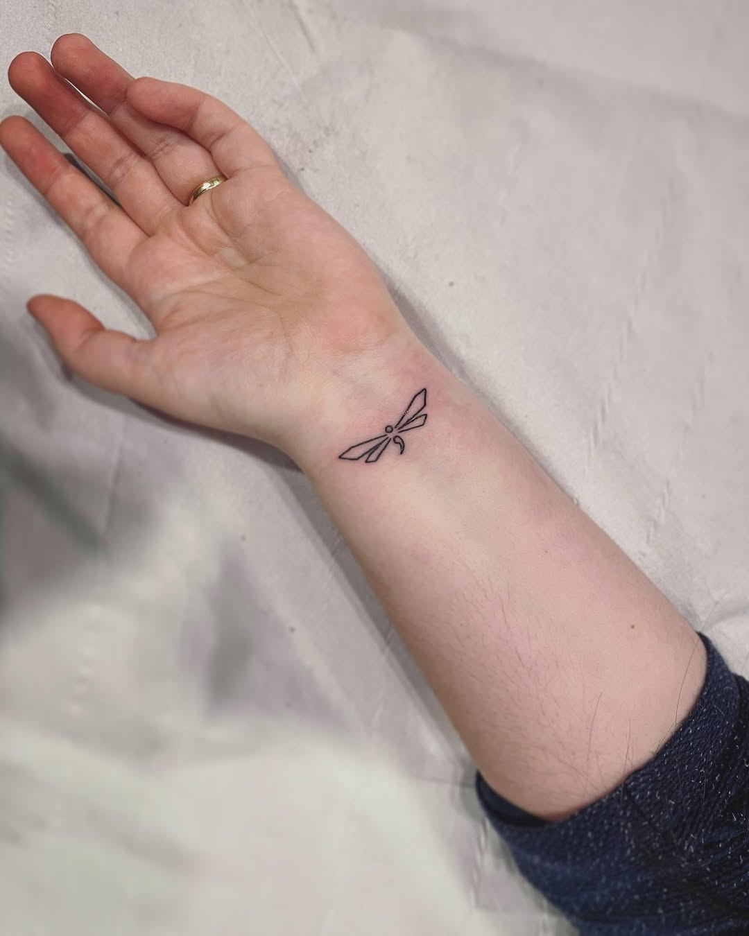 Delicate dragonfly tattoo embodying resilience and hope