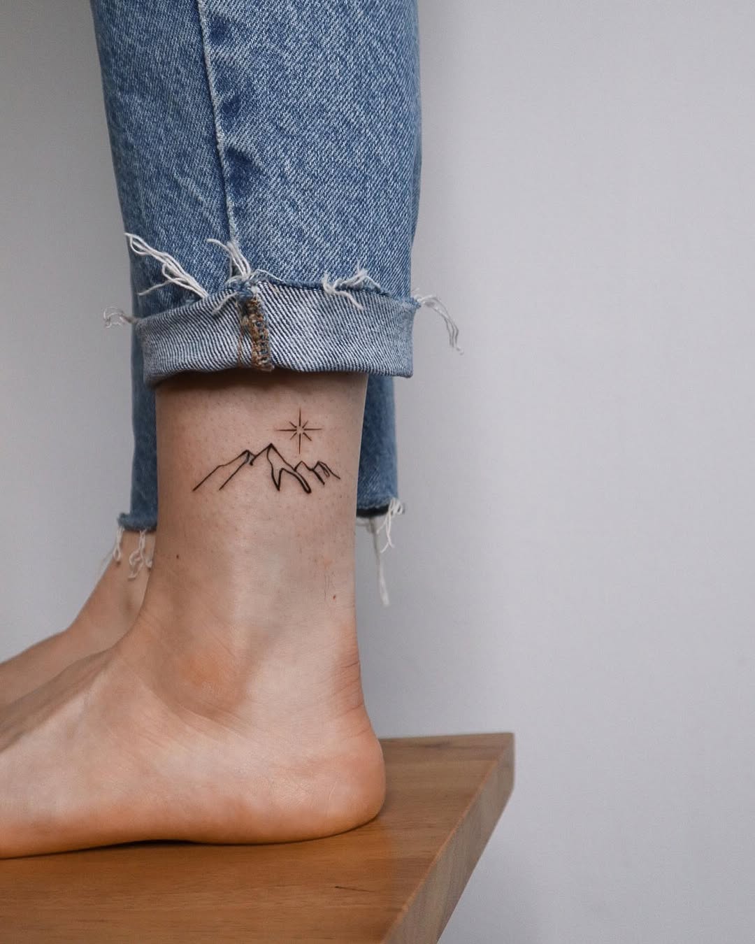 Stylish ankle tattoo with mountain sunset design