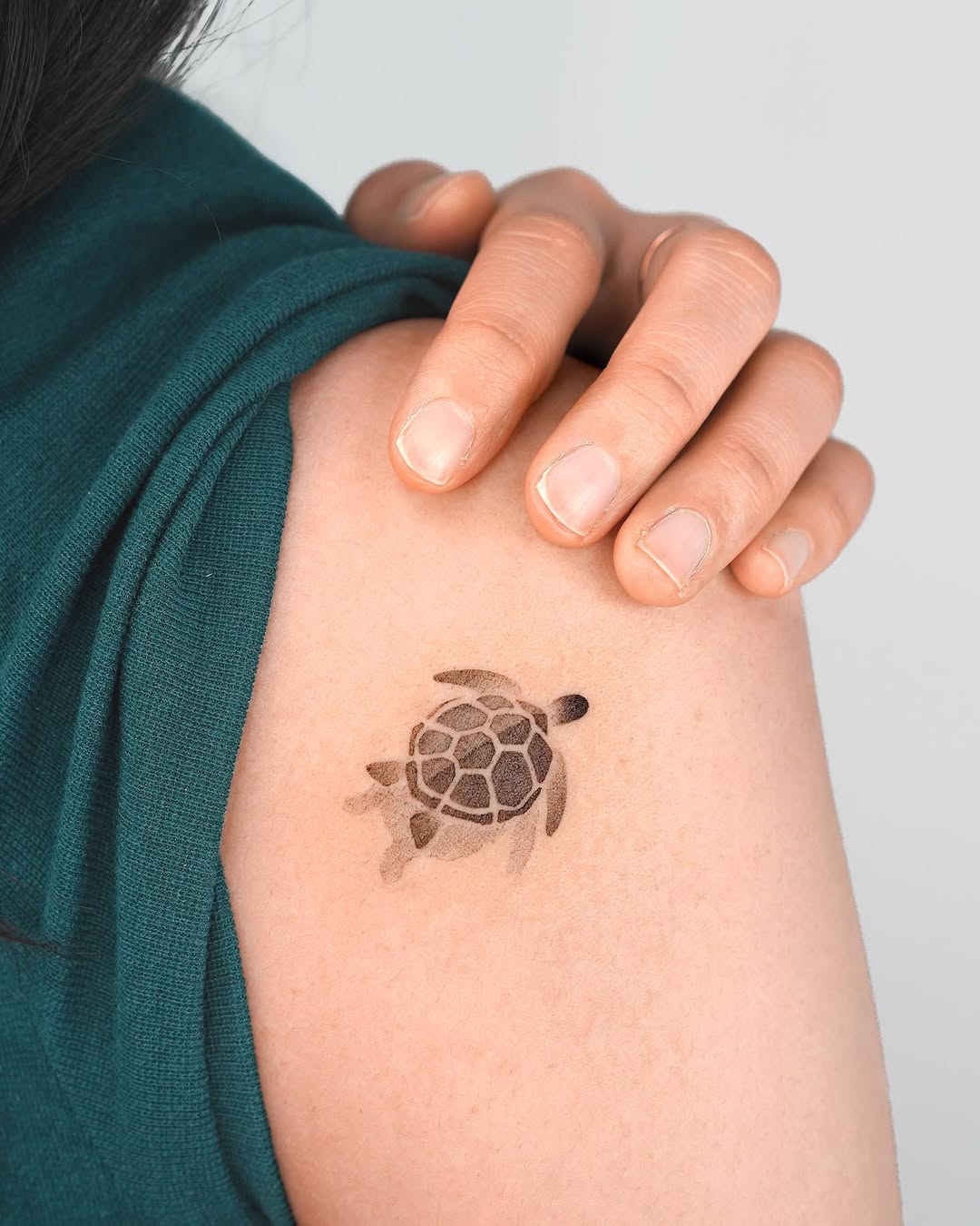 Stylish minimalist turtle tattoo on shoulder