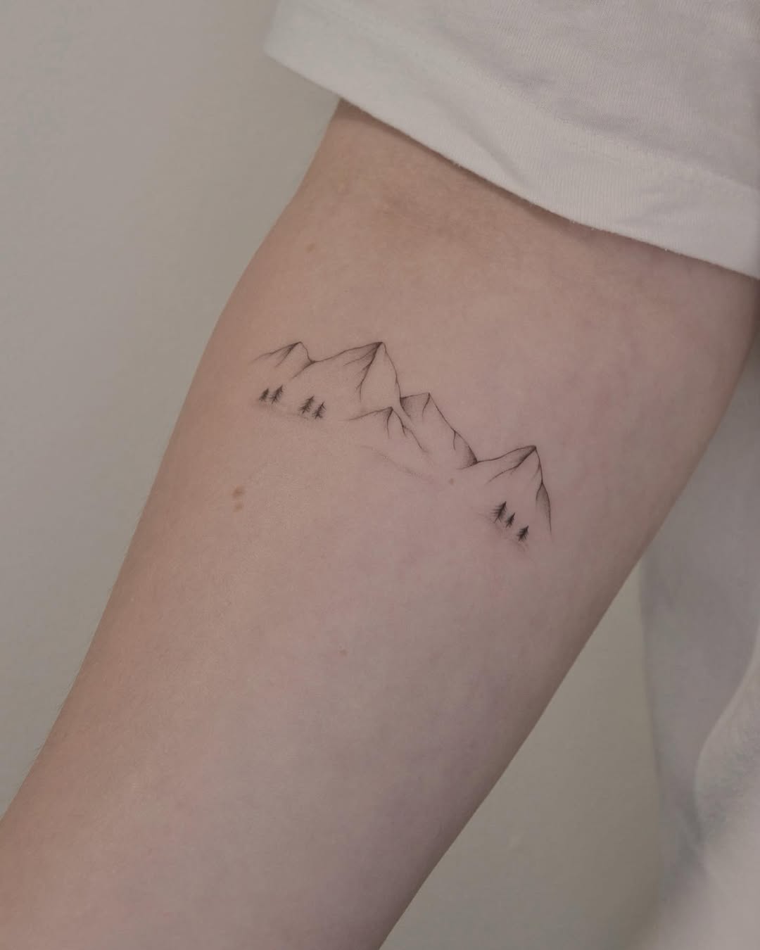 Minimalist mountain tattoo with a natural vibe