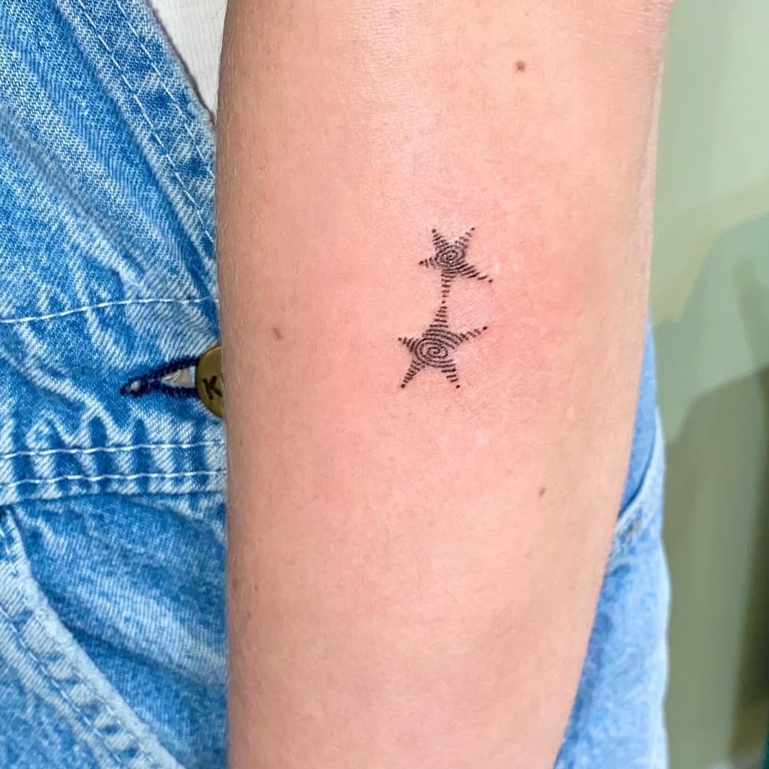 Elegant black star tattoo with swirling lines