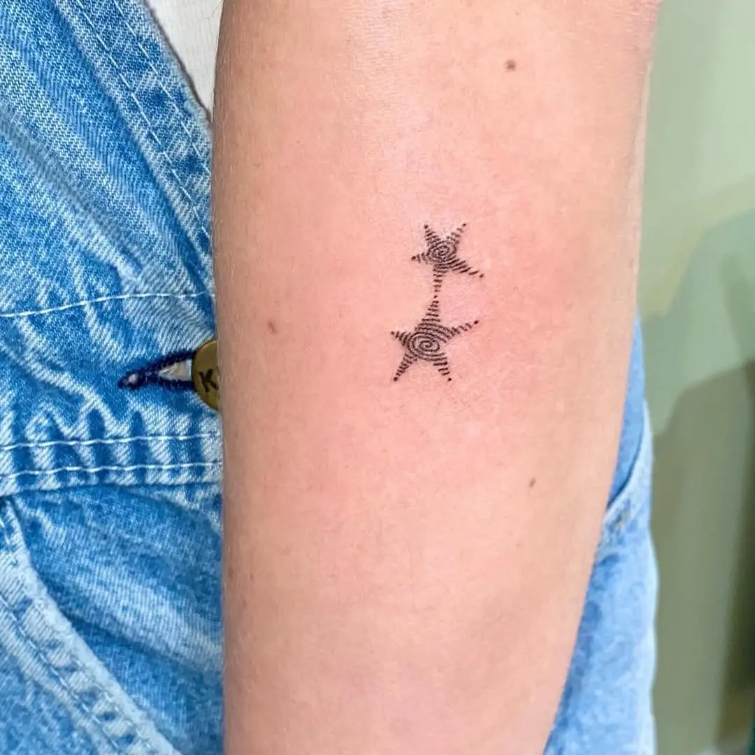 Elegant black star tattoo with swirling lines