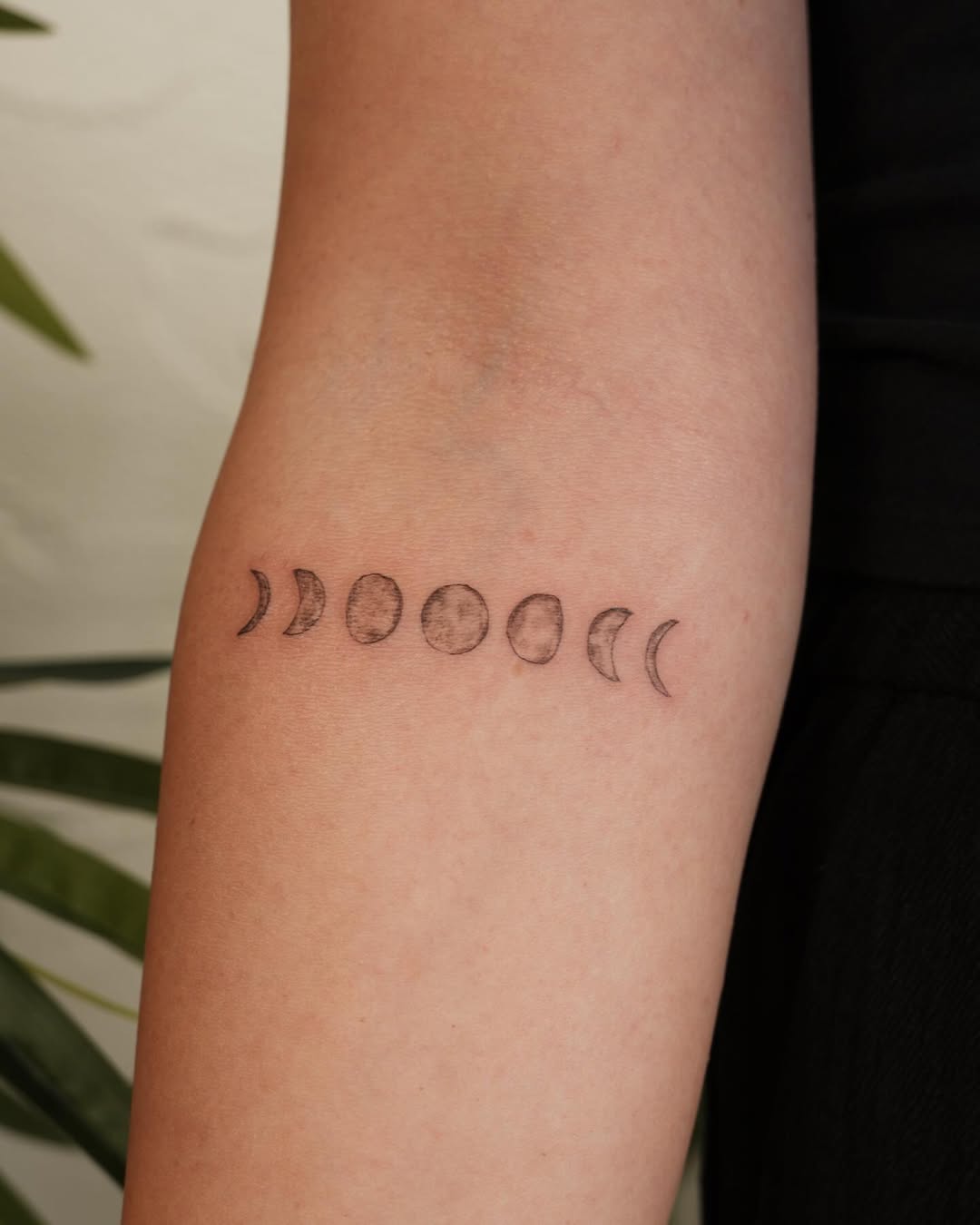 Elegant moon phases tattoo on the arm