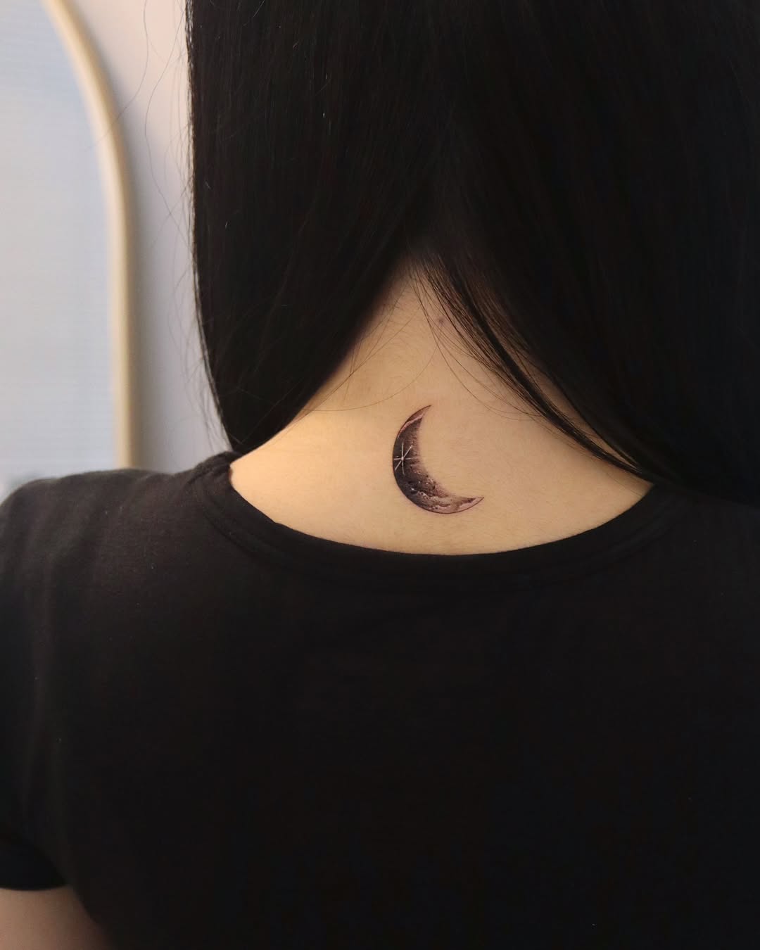 Elegant crescent moon tattoo on the neck