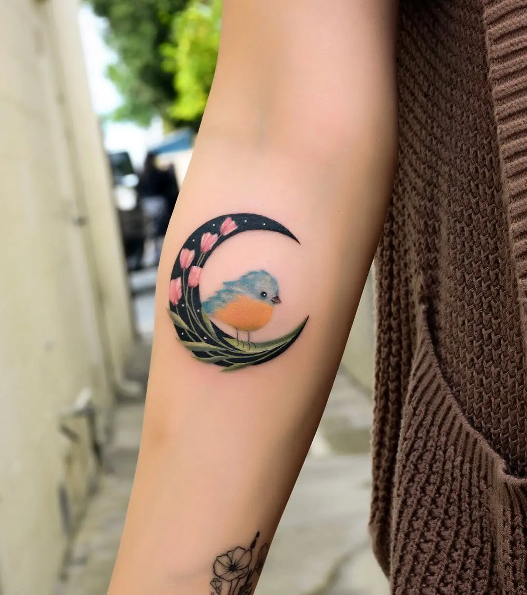 Charming bird nestled in a crescent moon tattoo