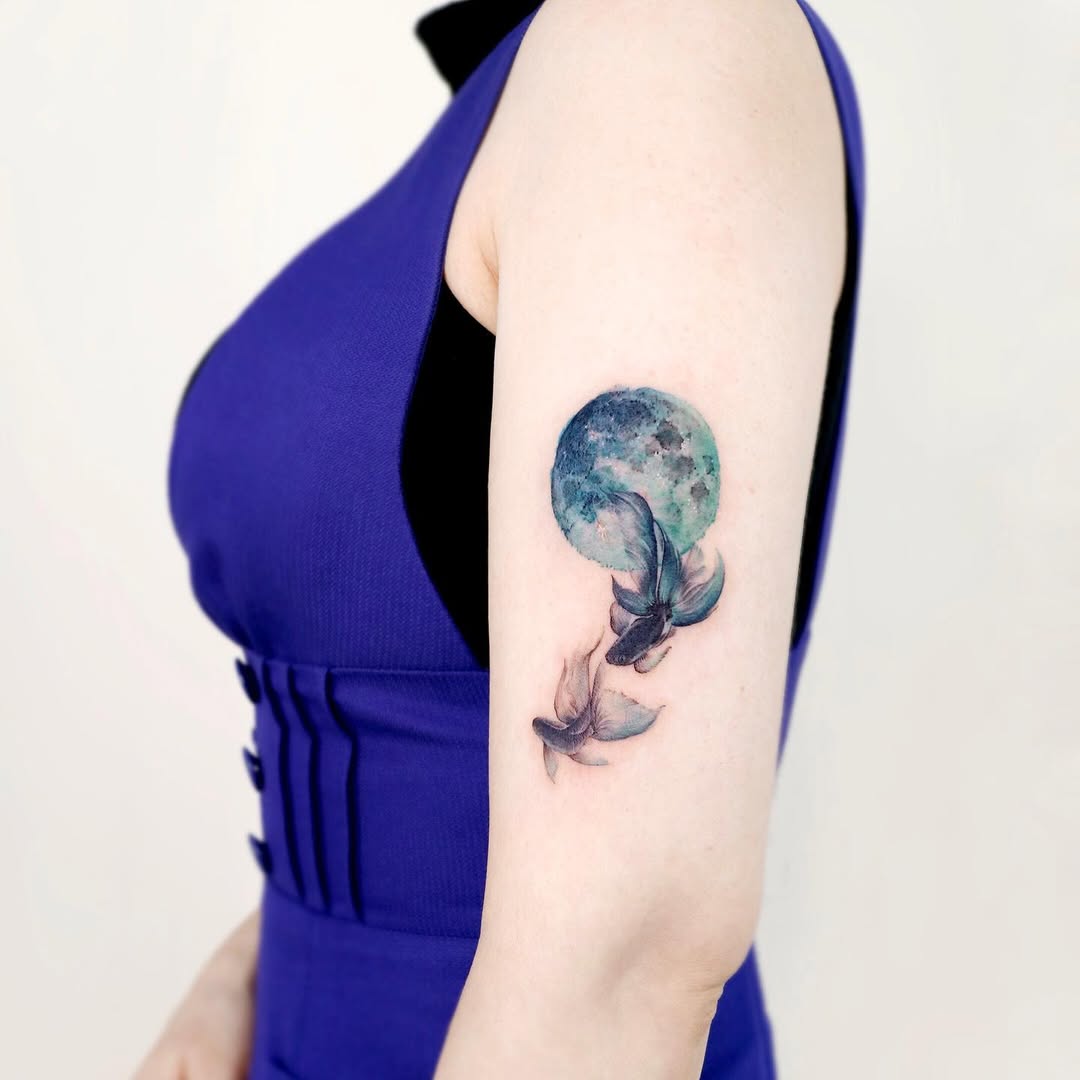 Elegant moon and fish tattoo on the arm