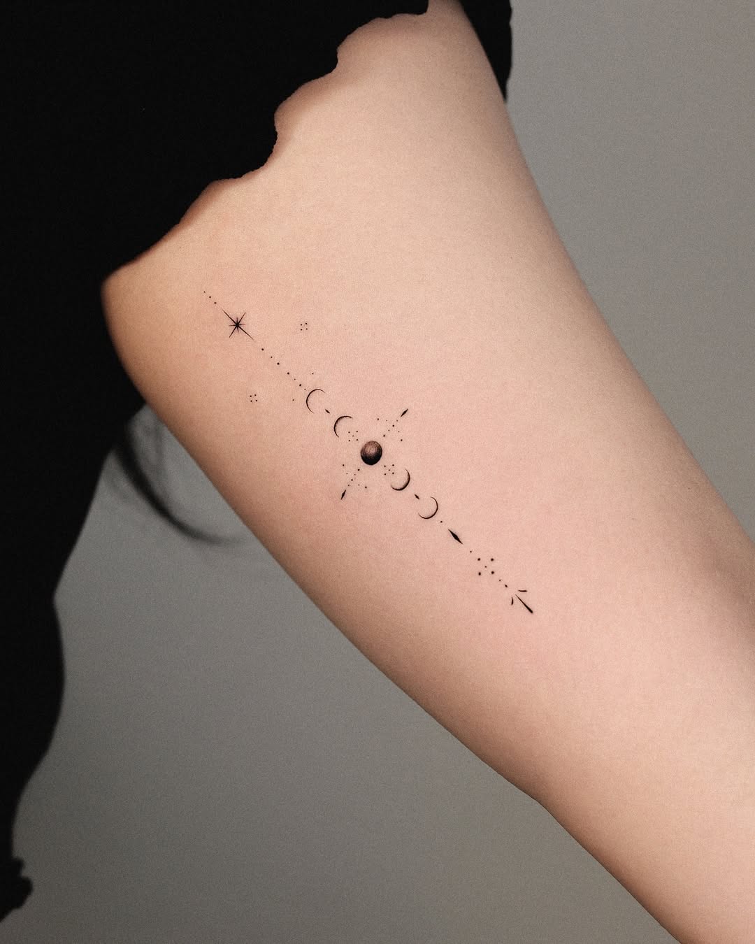 Elegant minimal moon phases tattoo on arm