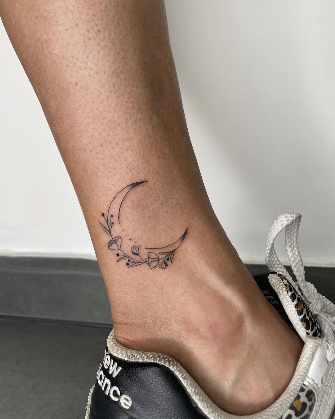 Elegant moon tattoo with floral accents